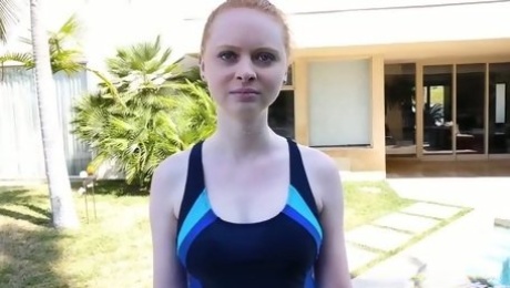 Cute redhead in swimsuit stands on knees to give a sensual blowjob